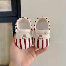 Pair of red-and-cream striped baby shoes with cream interiors