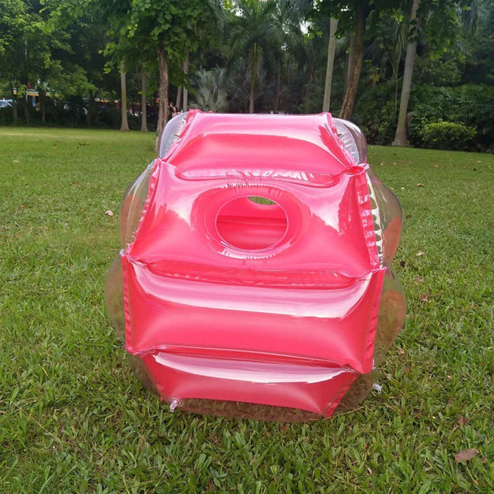 Front view of a red inflatable play ball standing on a lawn
