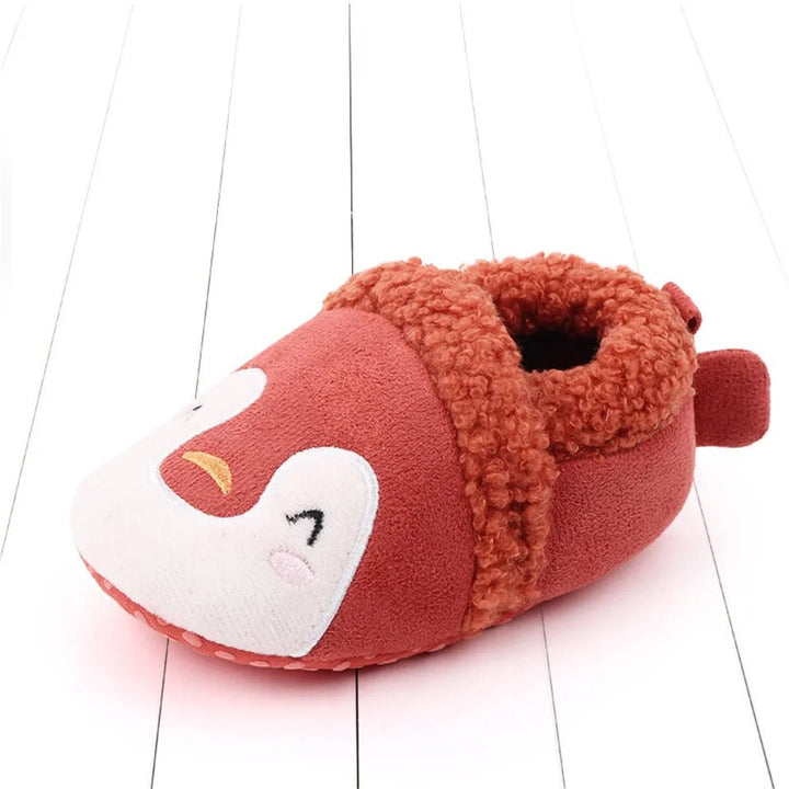 Red penguin baby slipper with a white face and fuzzy trim.