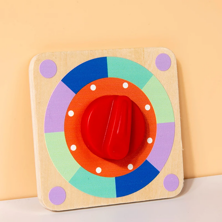 Wooden rotary-switch busy board with a large red dial and a multicolored ring.