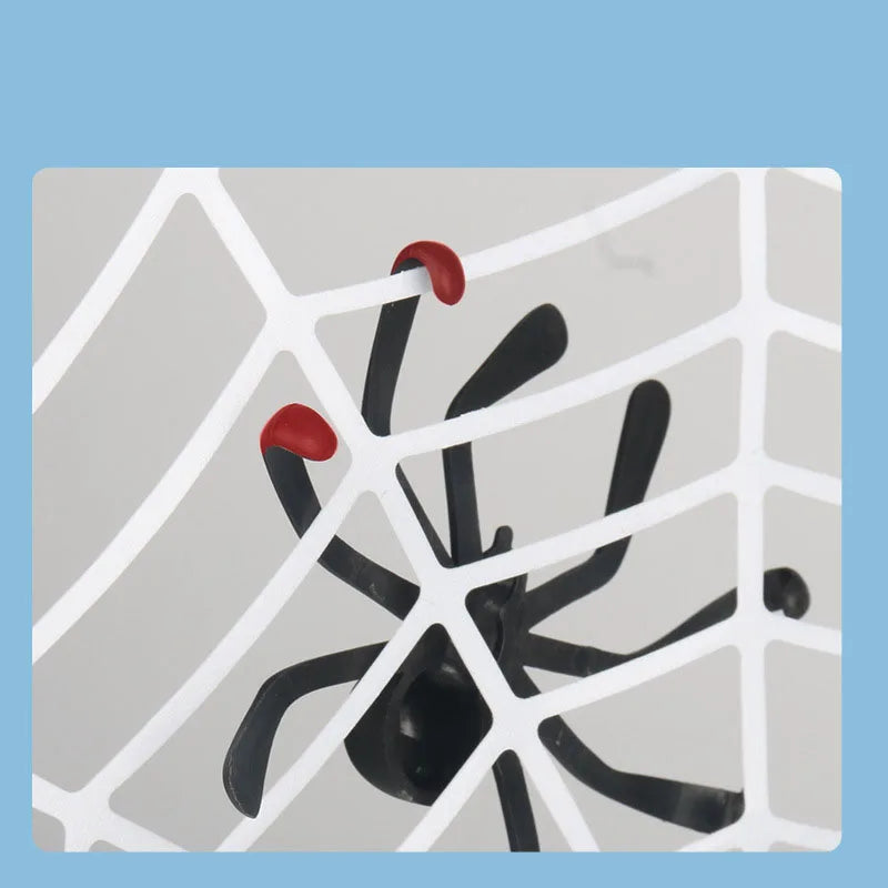 Close-up of a black spider with red-tipped legs against the white web