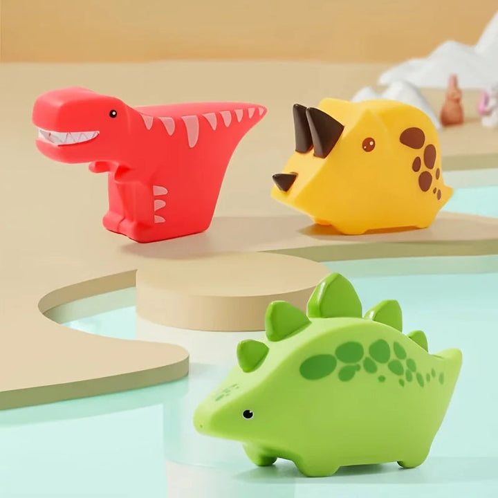 Red, yellow, and green dinosaur bath toys on pastel display stands