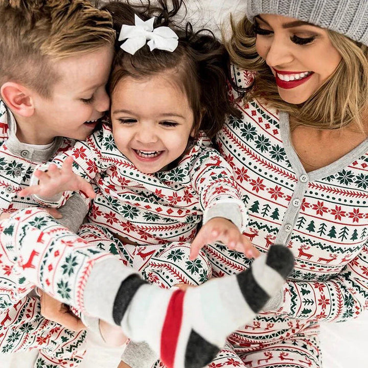 Close-up of a mother and two children wearing Christmas pajamas with reindeer and snowflake patterns