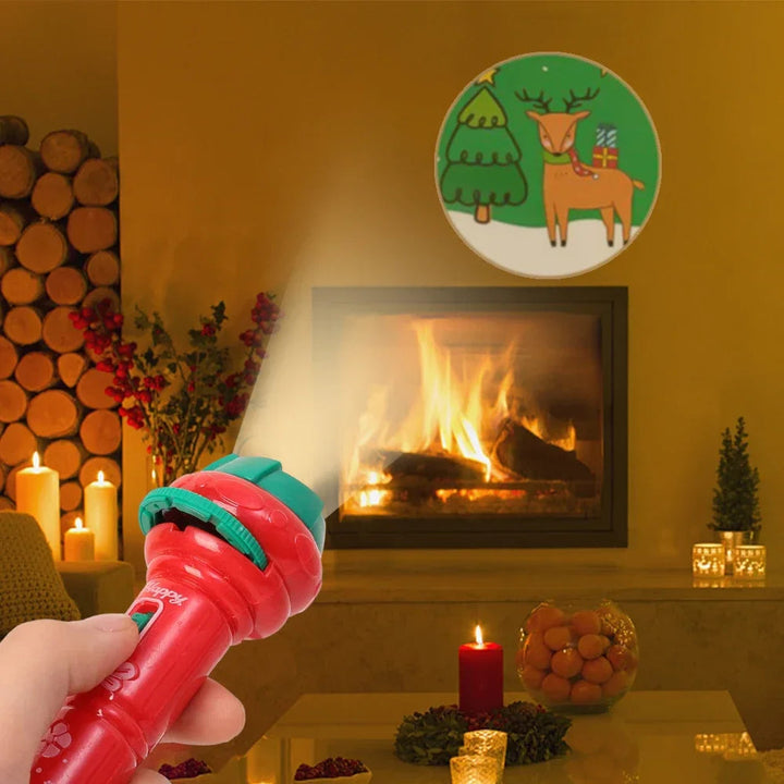 Red projection flashlight casting a Christmas tree and reindeer scene onto a wall near a fireplace