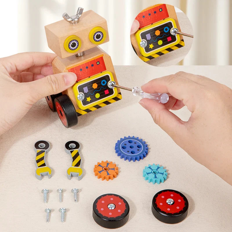 Hands using a screwdriver on the wooden robot, with wheels, gears, and screws on the table