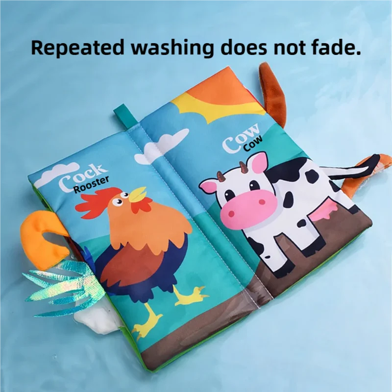 Open cloth book showing rooster and cow pages with colorful fabric tails