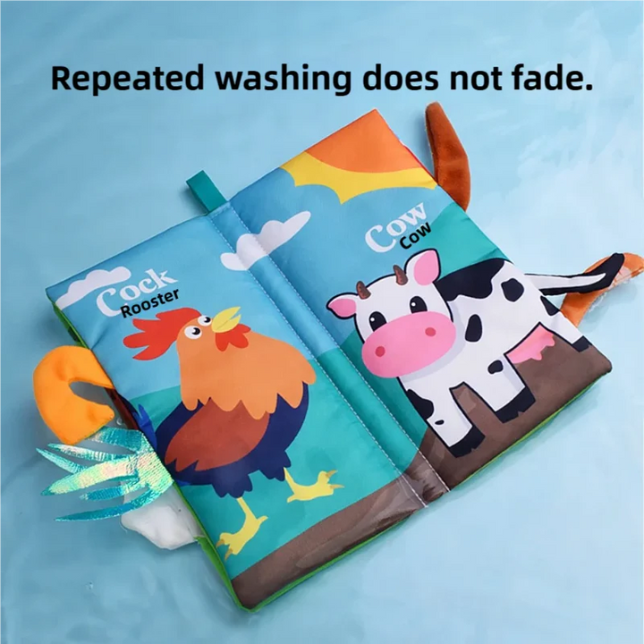 Open cloth book showing rooster and cow pages with colorful fabric tails