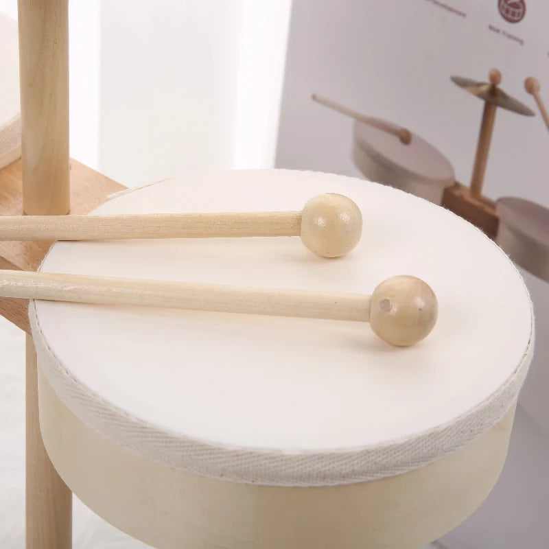 Two rounded-tip wooden drumsticks resting on a white drumhead