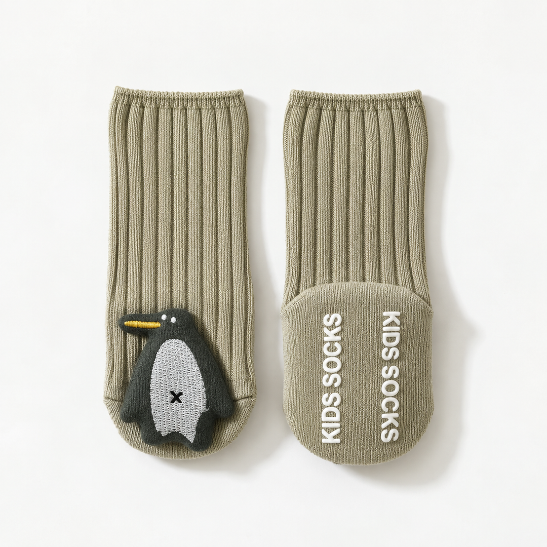 Sage green penguin baby socks showing the character front and non-slip sole