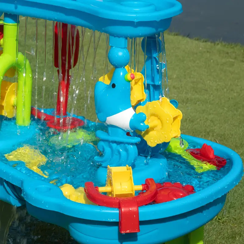 Blue animal-shaped spinner and yellow wheel beneath the water table&