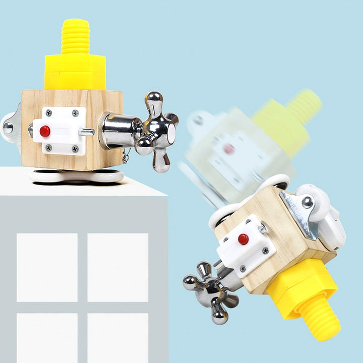 Wooden activity cube shown upright and tilted, with a yellow screw and faucet-style handle