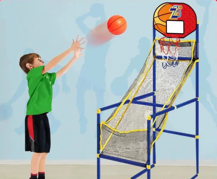 Child shooting a basketball toward a freestanding hoop with a netted return ramp