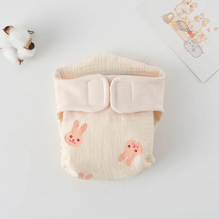 Cloth diaper with small pink rabbit faces and a cream waistband