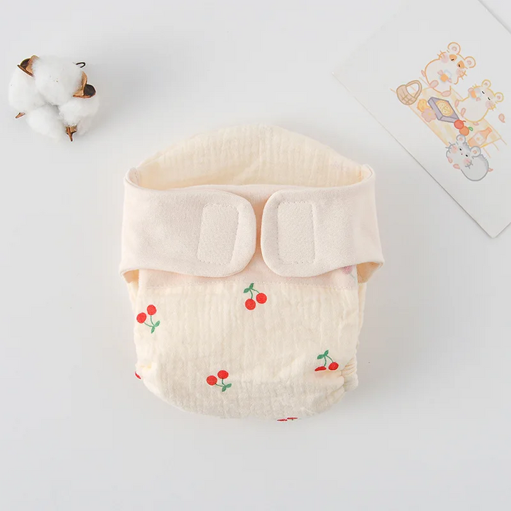 Cloth diaper with small red cherry prints and a cream hook-and-loop waistband