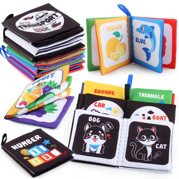 Soft fabric books stacked beside open animal, color, shape and fruit pages