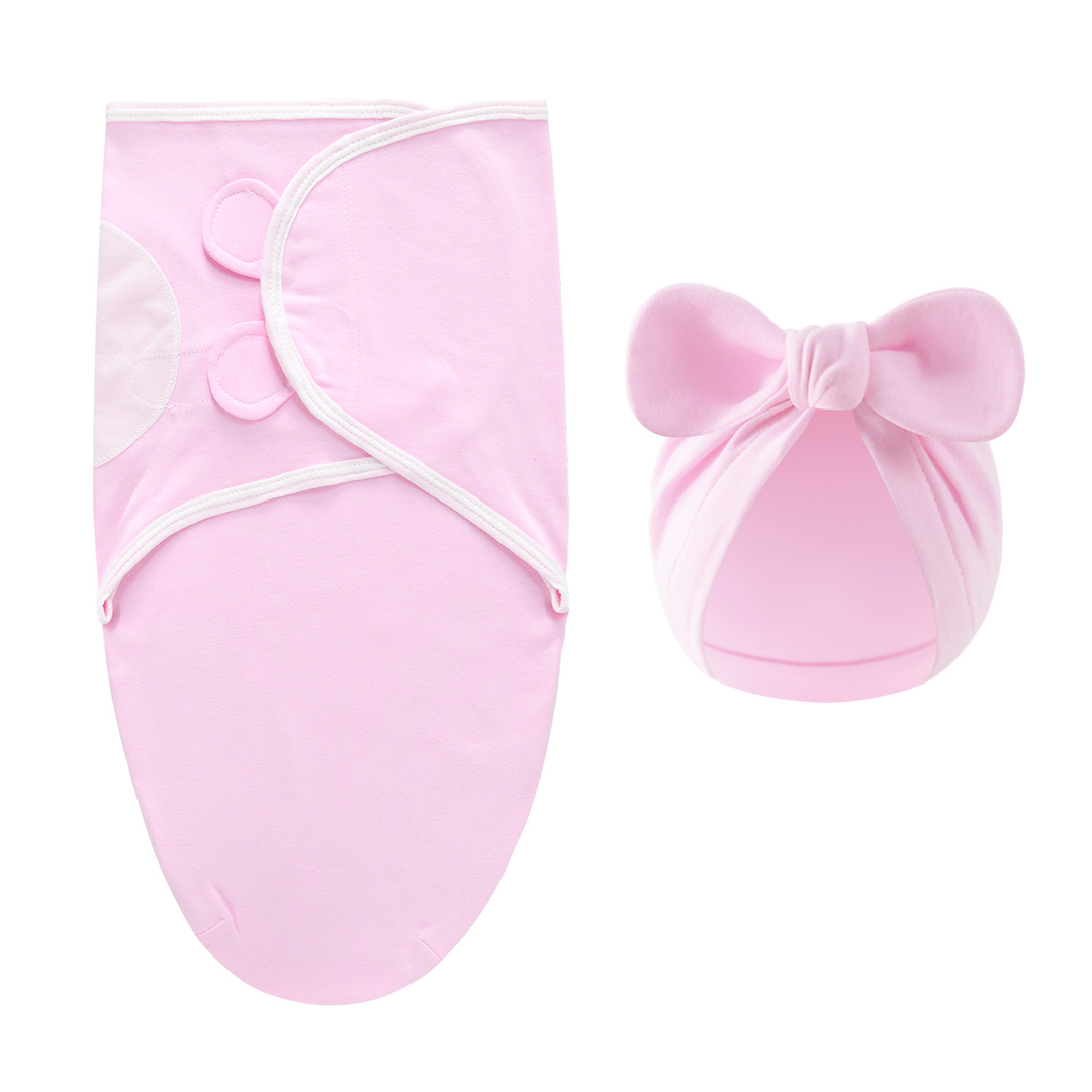 Soft pink swaddle blanket with white edging and a matching bow hat