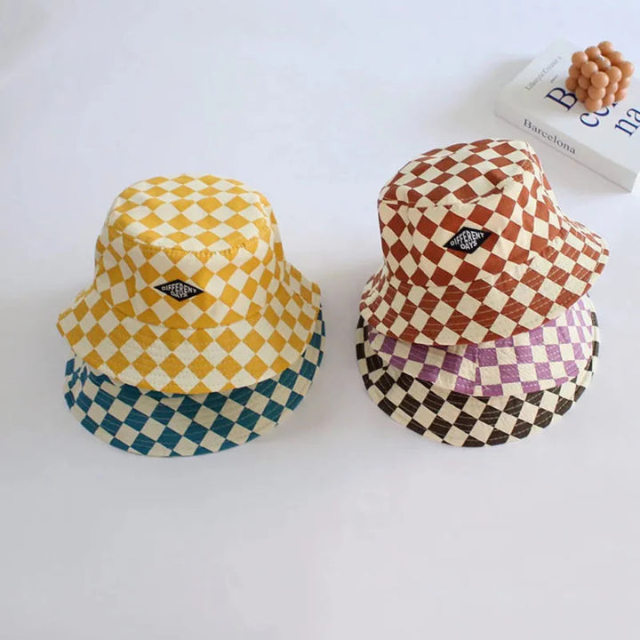 Stacked checkered bucket hats in yellow, blue, orange, purple, and coffee