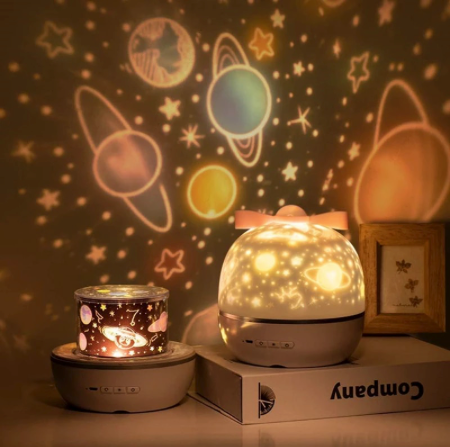 Star projector night light with planet and star patterns glowing across a wall