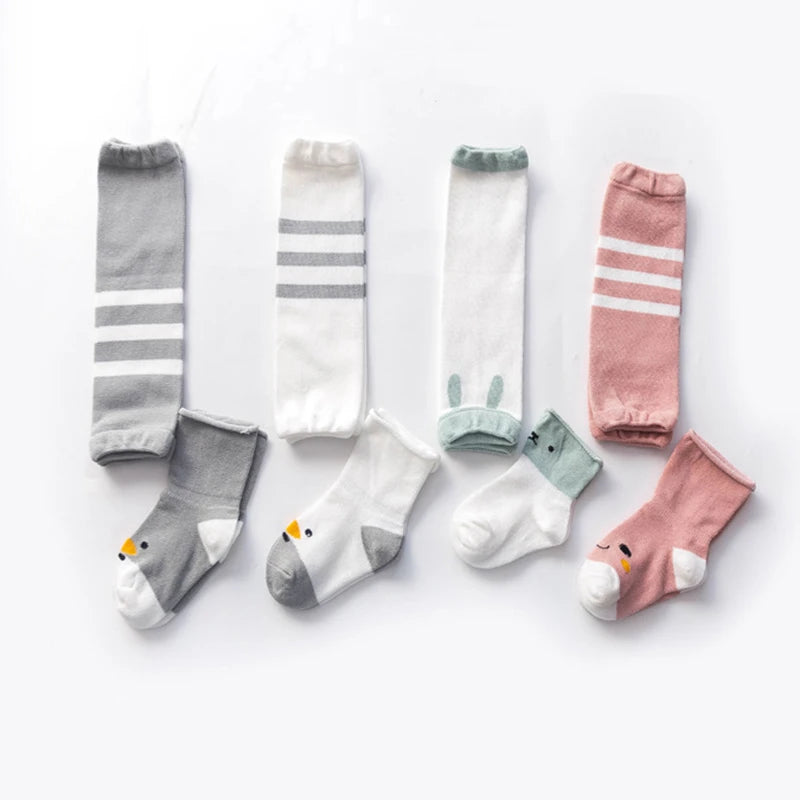 Striped and bunny-detail baby leg warmers laid out with coordinating socks.