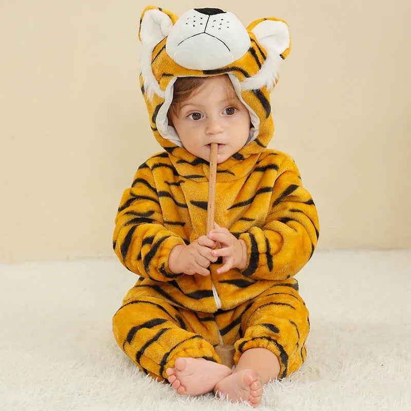 Baby seated on a rug in a striped tiger romper with the animal hood up.
