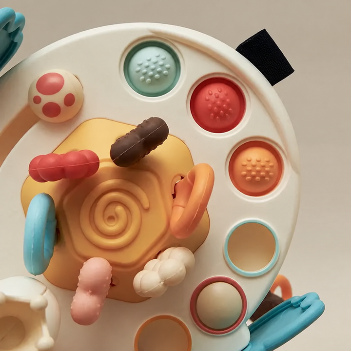 Close-up of the swan-style sensory toy with textured buttons and colorful cord ends