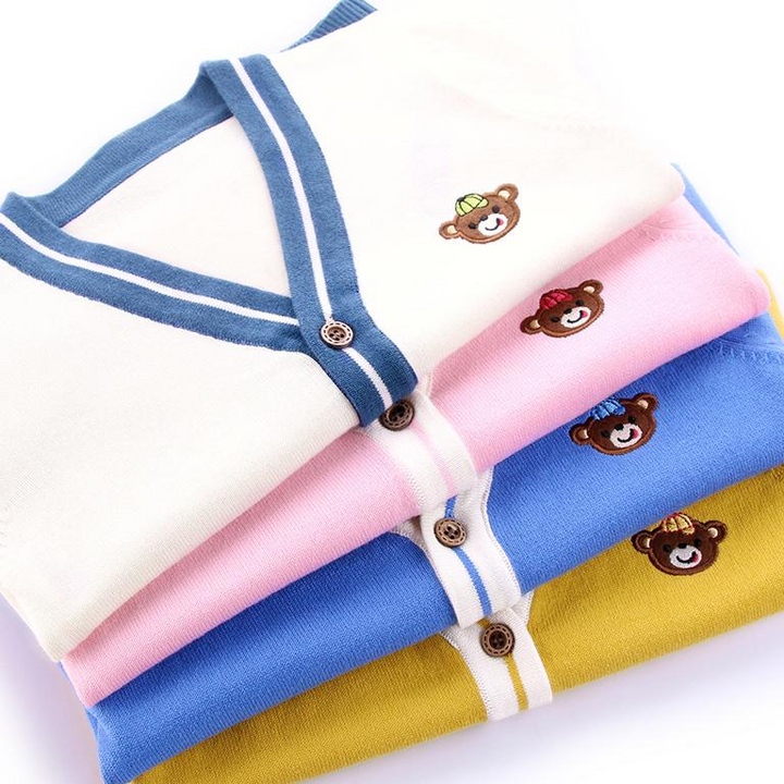 Folded teddy bear cardigans in beige white, pink, blue, and yellow with contrasting V-neck trim