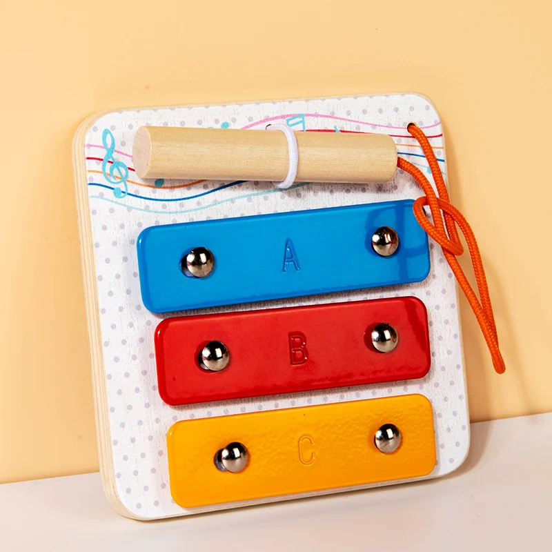 Wooden tap piano busy board with three colored bars and a tethered wooden mallet.
