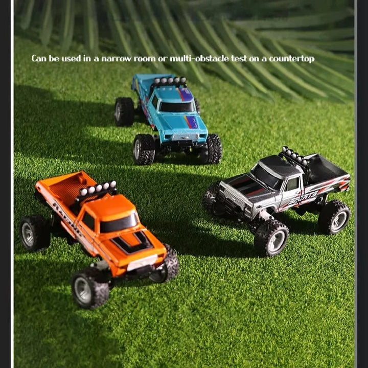 Orange, blue, and gray mini RC trucks arranged on grass.