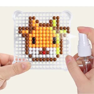 Tiger bead design on a clear plate with a water spray bottle held beside it