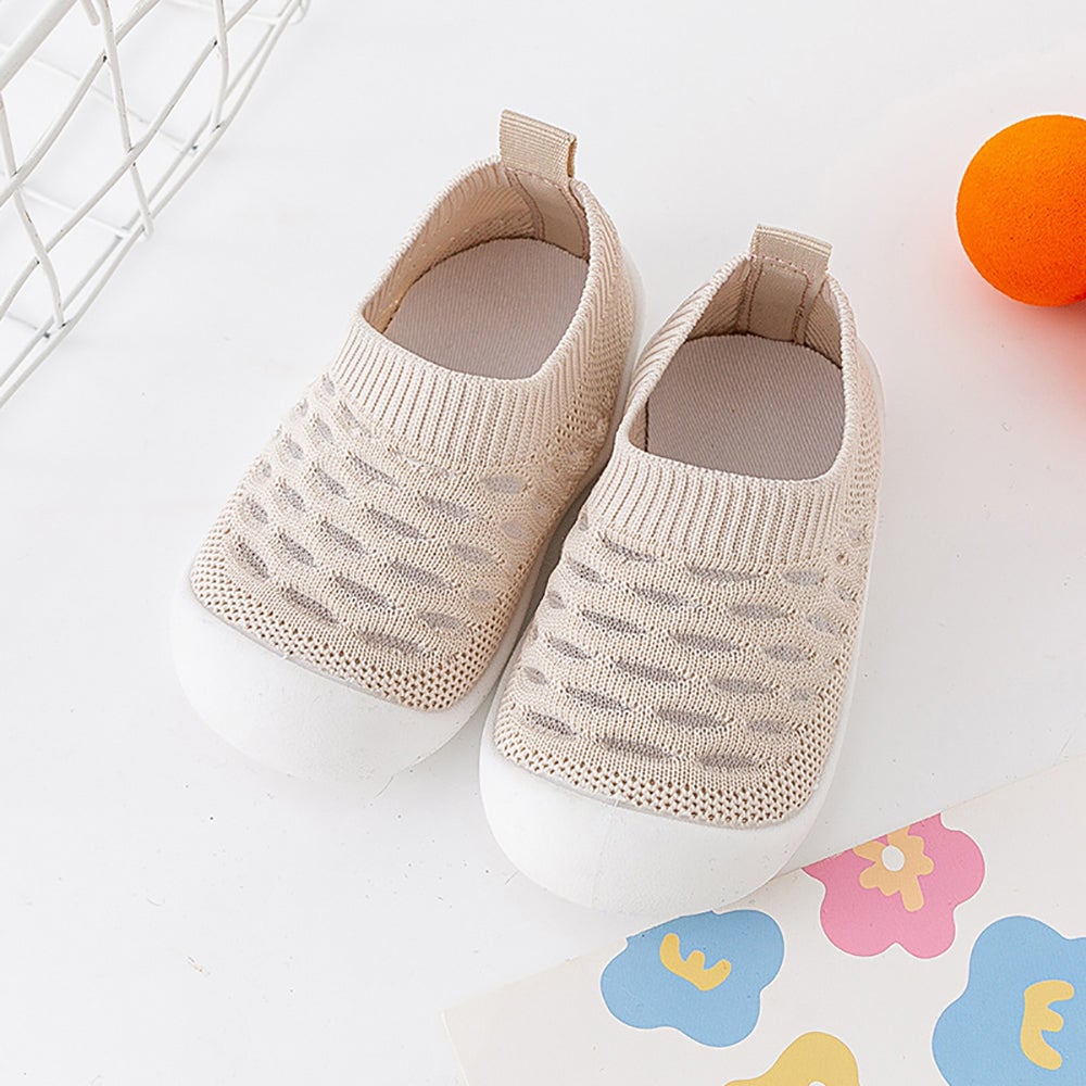 Pair of beige knit slip-on shoes with ribbed openings and white soles