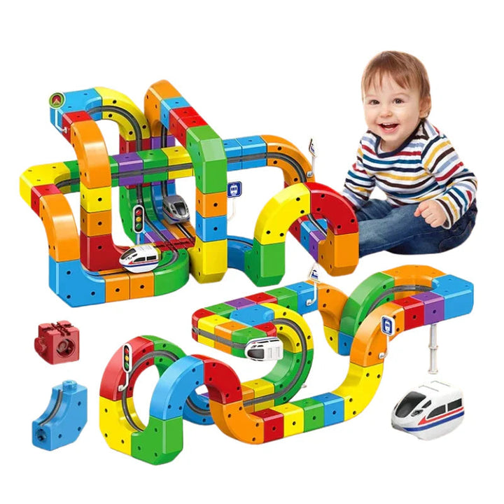 Two colorful train track layouts with white trains, loose blocks, and a seated child