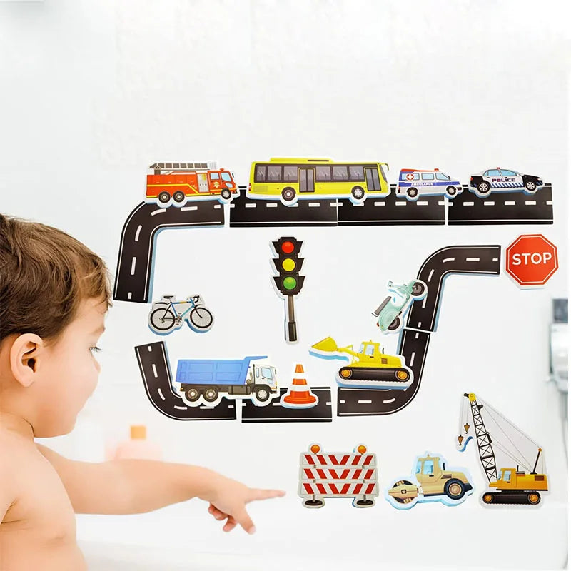 Child pointing to a foam road layout with vehicles and traffic signs on a bathtub wall