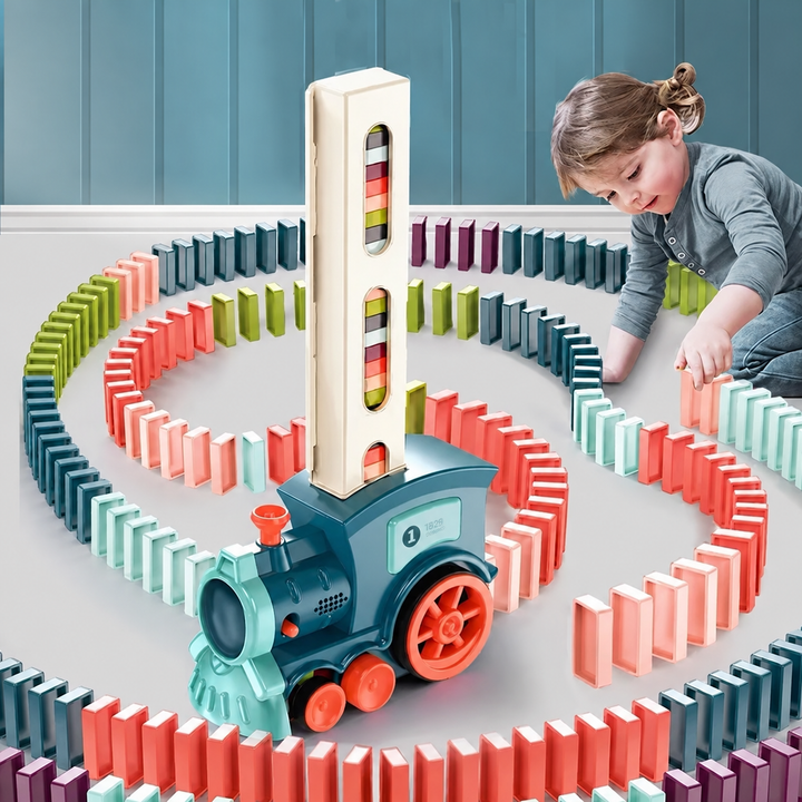 Child arranging colorful domino trails around a teal toy train with a tall loading tower