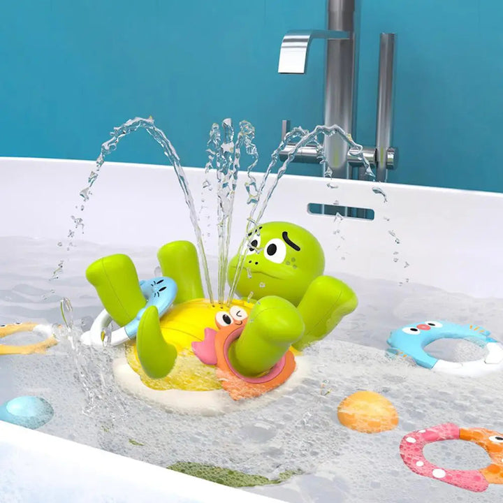 Green turtle fountain spraying water in a bathtub with colorful rings floating nearby.