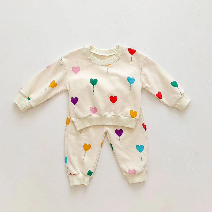Two-piece cream baby tracksuit with colorful heart balloons, long sleeves and cuffed pants