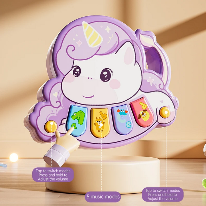 Finger pressing a button on a purple unicorn piano with four colorful keys