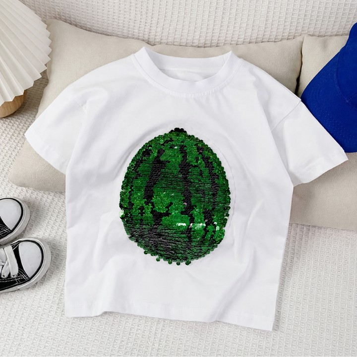 White watermelon sequin T-shirt laid on a sofa with the green rind design facing up