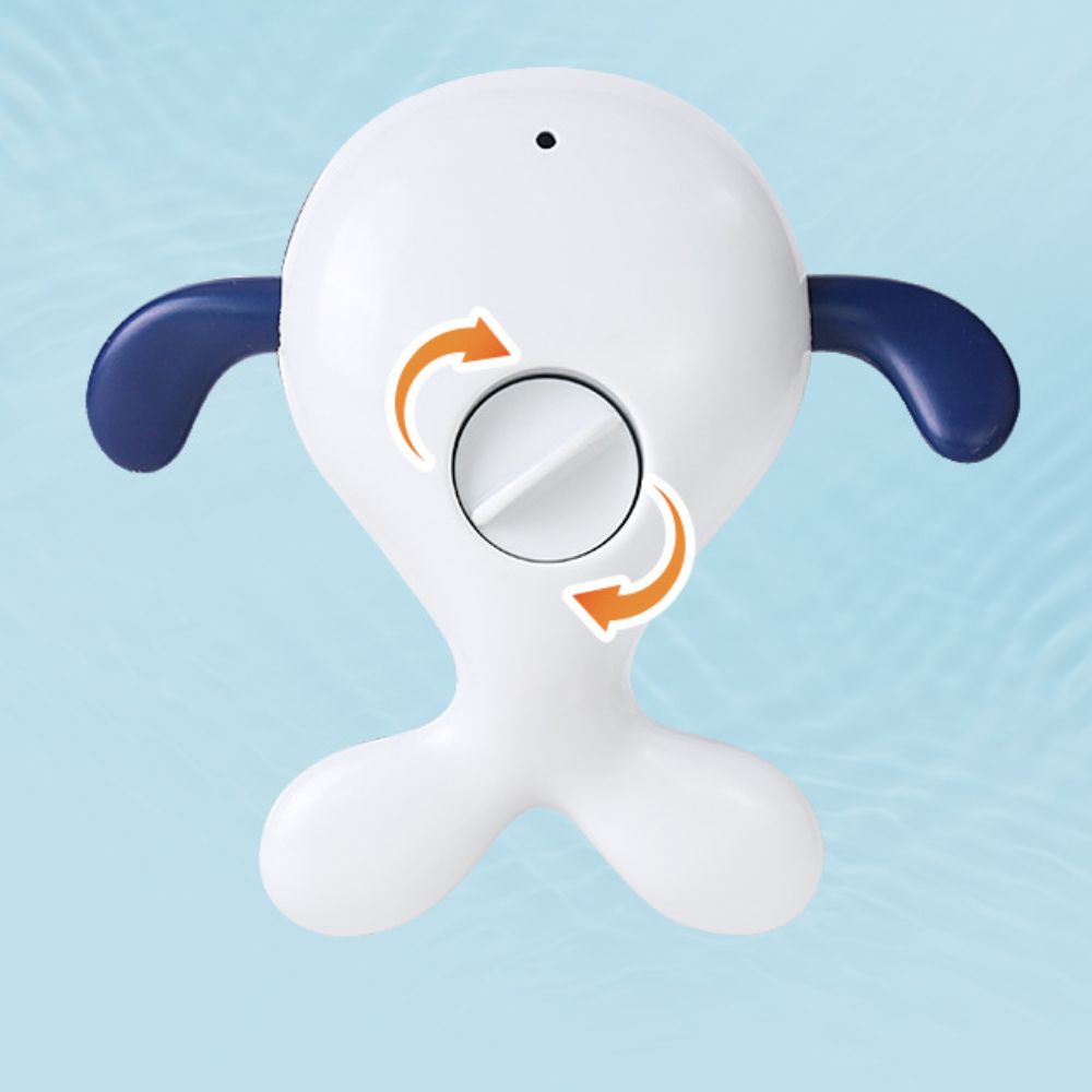 Underside of a whale bath toy showing navy fins, a white tail and a turning dial.