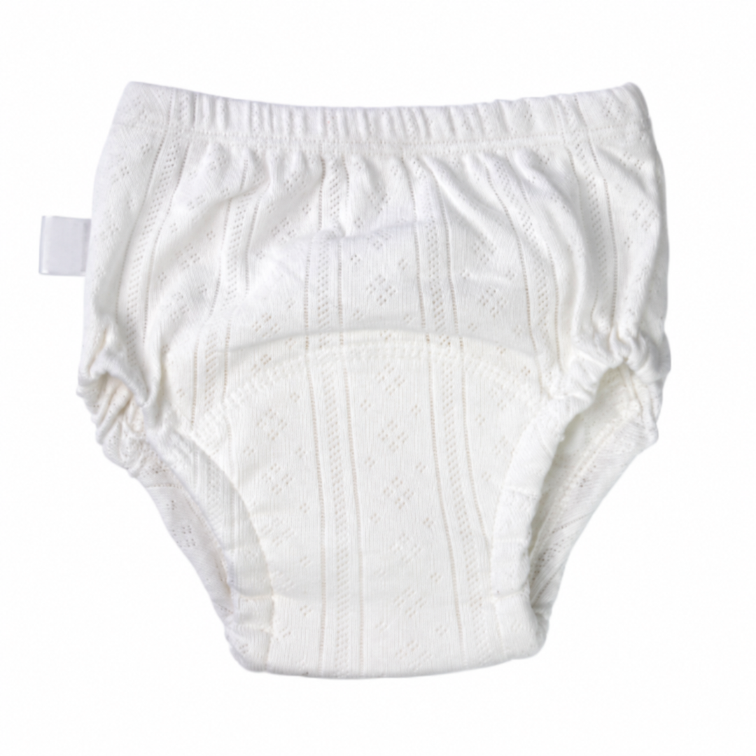 White cotton training pants with elastic waist and leg openings and a U-shaped absorbent panel.