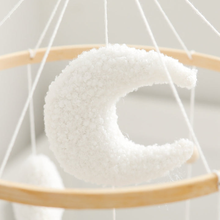 Textured white crescent moon with hanging cords and a wooden ring