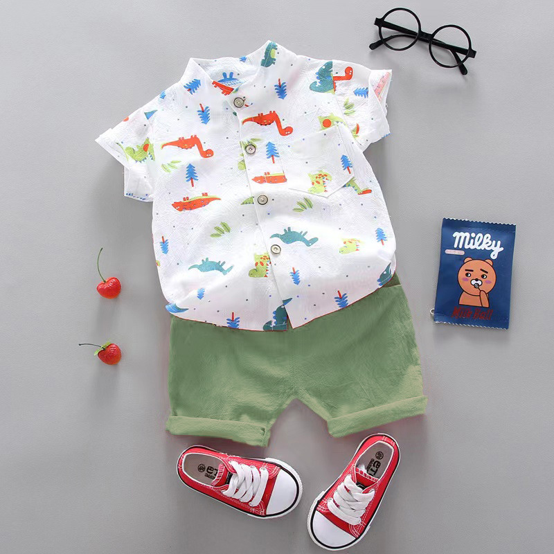 White multicolor dinosaur-print shirt with green cuffed shorts