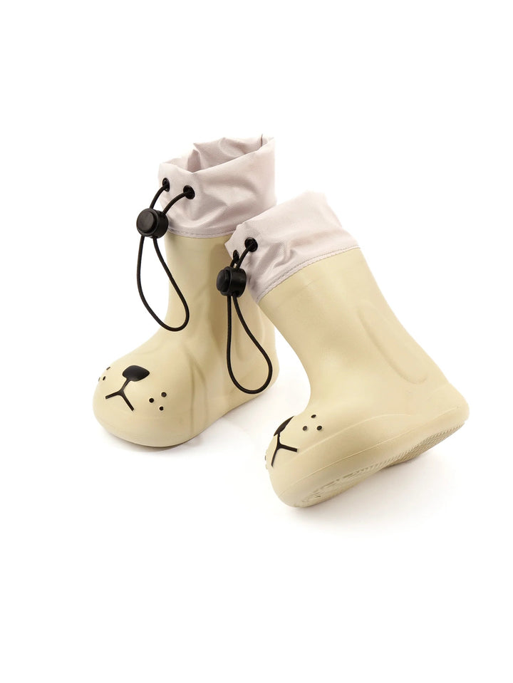 White dog-face rain boots in an angled view with pale cuffs and black drawcord fasteners