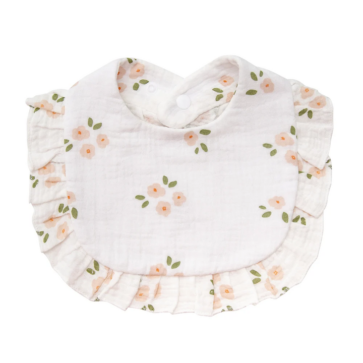 White cotton baby bib with peach-colored blossoms, green leaves, and ruffled trim