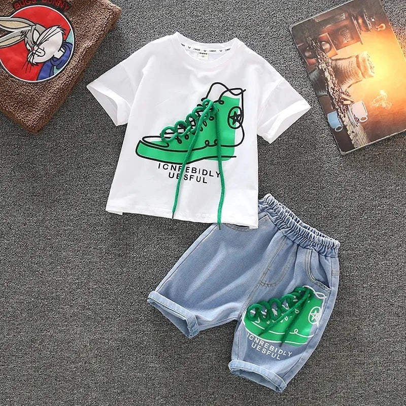 White short-sleeve T-shirt and blue denim shorts with matching green sneaker graphics, laid flat