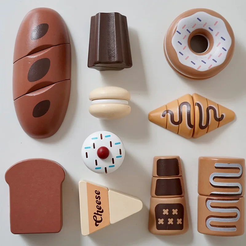 Wooden pretend bread, doughnuts, croissant, sweets, and cheese arranged on a tabletop