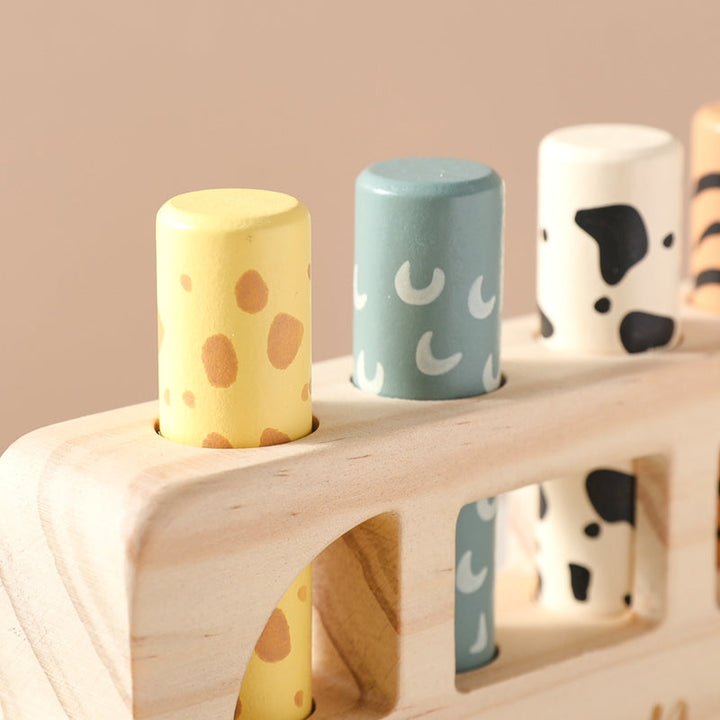 Close-up of colorful patterned pegs and the wood grain on the toy bus