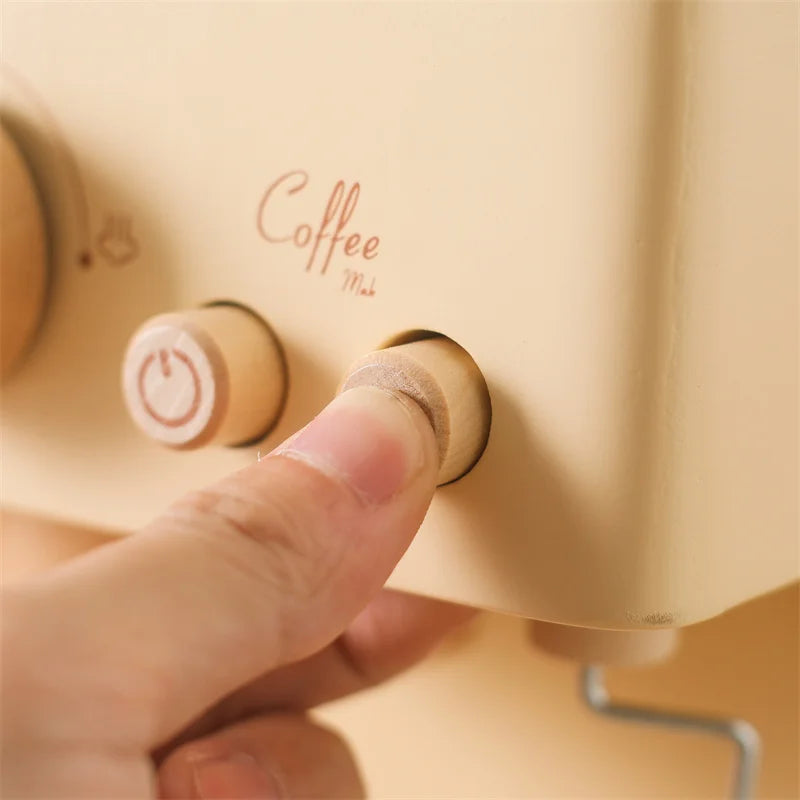 Finger pressing a wooden button on the pretend espresso machine.
