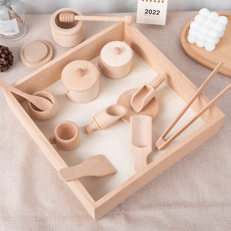 Wooden cups, lidded pots, scoops and kitchen utensils arranged in a wooden tray.