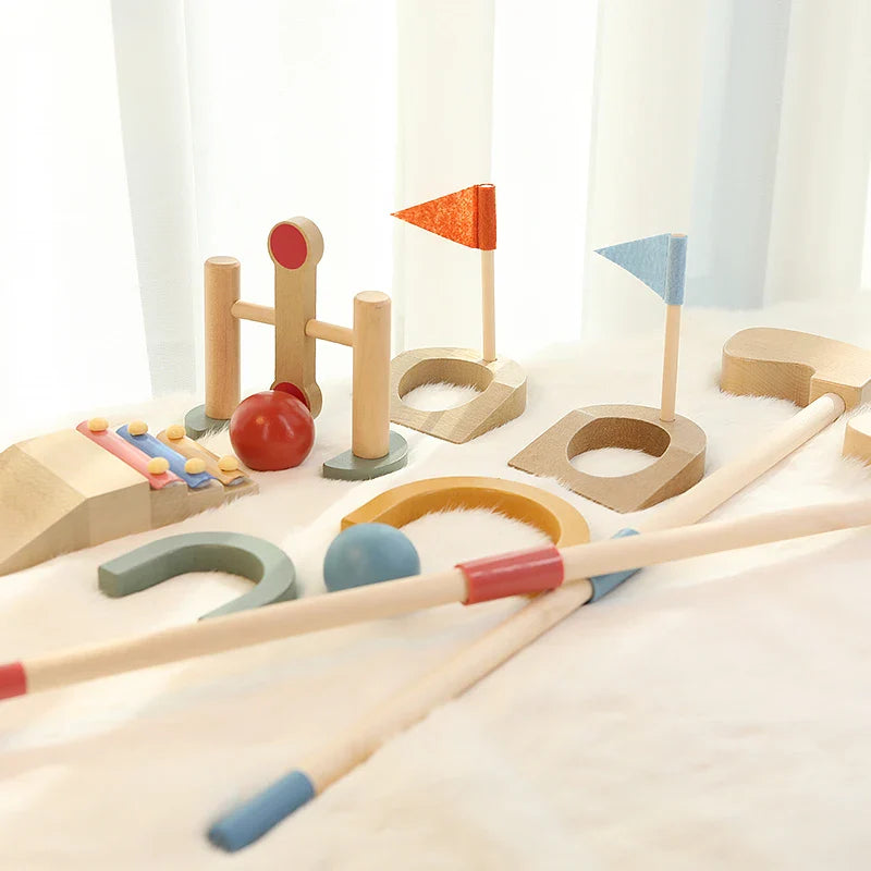 Wooden mini golf course with two flag targets, clubs, arches and red and blue balls