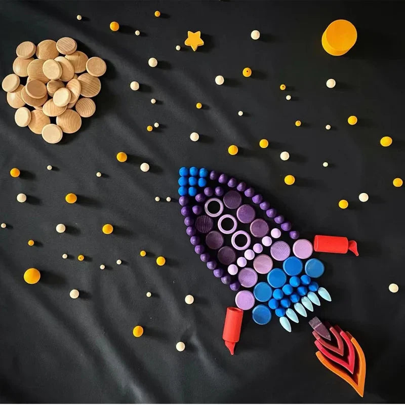 Wooden rings, discs, and pointed pieces arranged as a rocket against a starry black background
